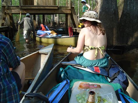 Woman canoeing with salami and beer.